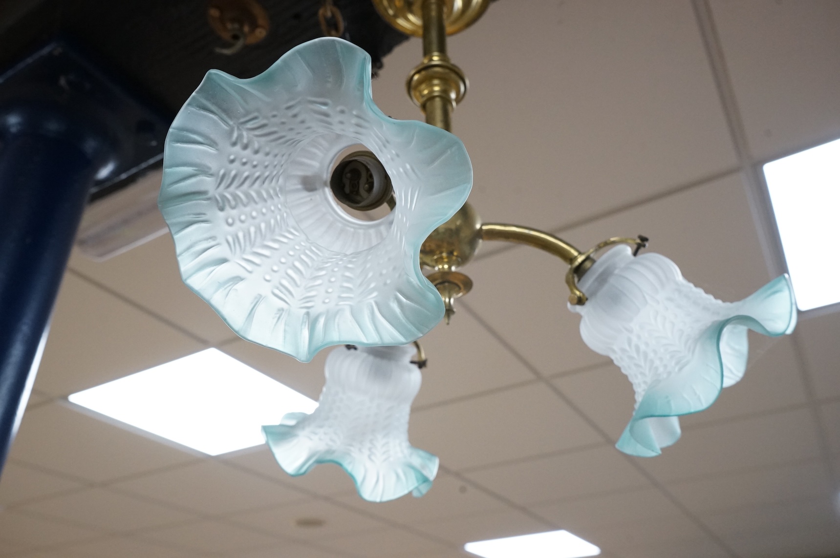 A brass three branch frosted shade ceiling light